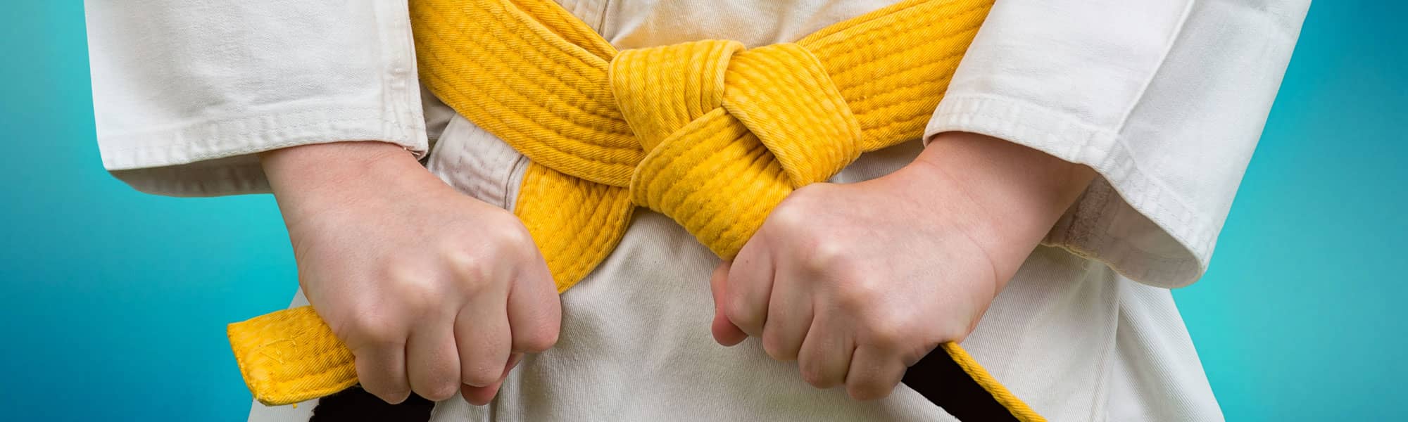 Karate student tying yellow belt